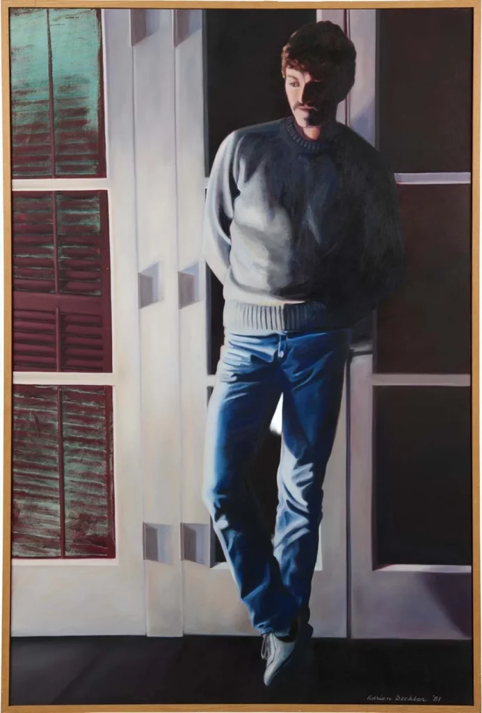 A man in a gray sweater and blue jeans stands with his arms behind his back, leaning against glass doors at the Hilliard Art Museum as sunlight casts shadows across him—a quiet moment at this Lafayette family friendly destination.