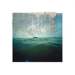A photo of a calm ocean with gentle waves under a blue sky. An irregular, semi-transparent textured overlay covers the upper part of the image, with a small distant island visible on the horizon.